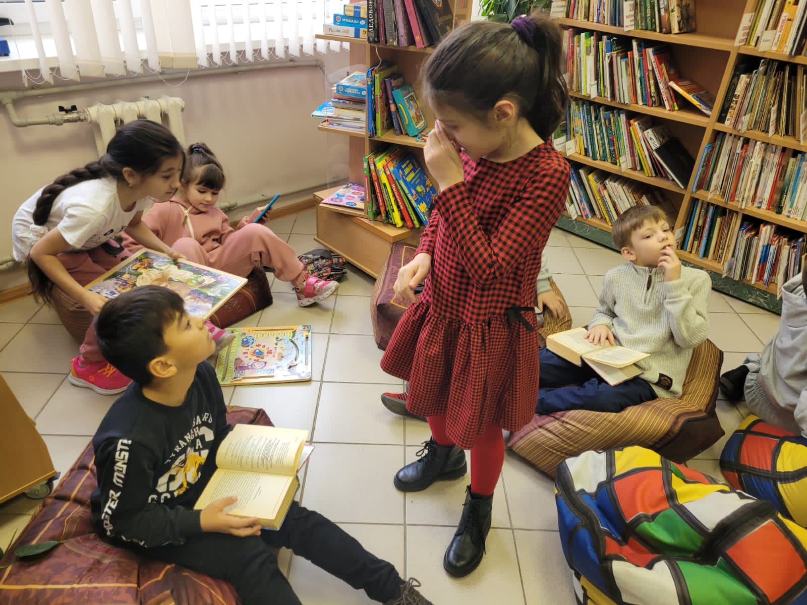 самостоятельный читатель. куча книг. библиотека для малышей. много книг. много книг в руках.